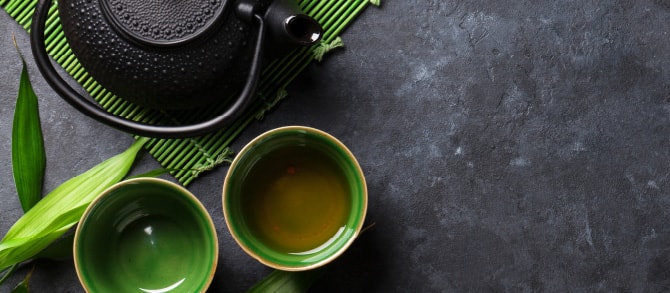 緑色のすだれに置いてある鉄の茶瓶と緑色の湯呑